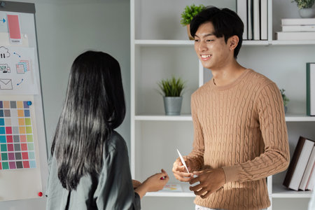 Young Professionals Discussing UX UI Design Concepts in a Modern Office Setting with Creative Business Elementsの写真素材