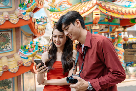 Joyful Travelers Celebrating Chinese New Year at a Vibrant Temple with Traditional Decorations and Festive Atmosphereの写真素材