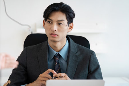 Professional business meeting with a focused young man in a suit and tie.の写真素材