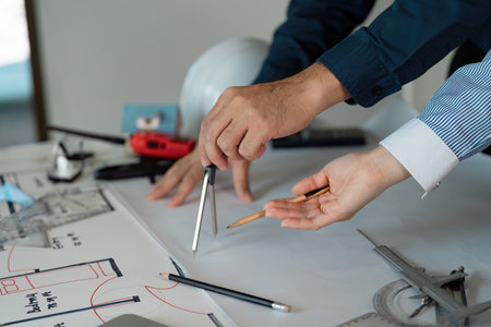 Collaborative architects discussing design plans with compass and pencil.の写真素材