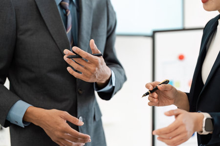 Business professionals discussing strategies with pens during a meeting.の写真素材