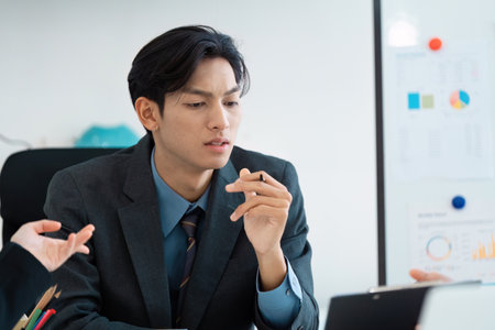 Thoughtful business professional analyzing reports during a meeting in the office.の写真素材