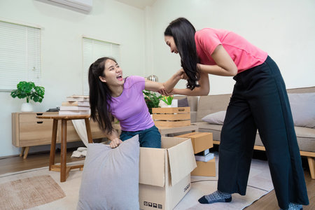 Joyful couple unpacking boxes and celebrating their new home together in a cozy living room.