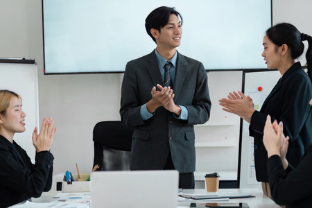 Confident business professional presenting to a diverse team in a corporate meeting.の写真素材