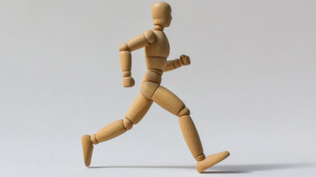 Dynamic wooden figure running in motion studio photography minimalist side view motion conceptの素材