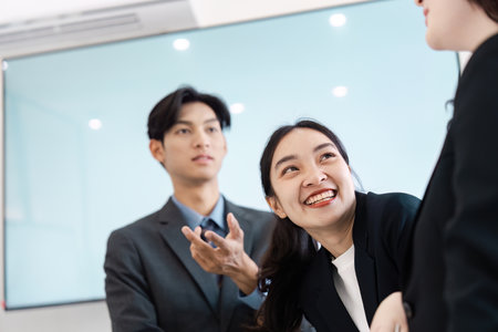 Colleagues sharing a light moment during a business meeting, showcasing camaraderie.の写真素材