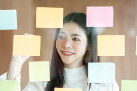 Business professional focused on sticky note organization for effective collaborationの写真素材
