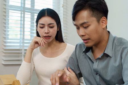 Couple reviewing property details and discussing with a real estate agent during a consultation.の写真素材