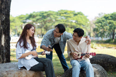 Musical friends enjoying a moment outdoors with ukulelesの写真素材