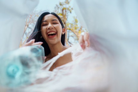 Joyful Recycling. Young woman joyfully discovering recyclables from a unique perspective while...