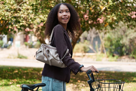 Eco-Conscious Commuting and Stylish Lifestyle. A woman with her bicycle smiling in a natural...