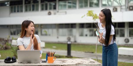 Friendship and Studying. Two students joyfully engaging in a lively discussion about schoolwork outside.の写真素材