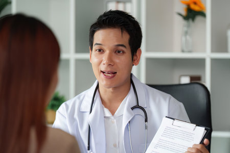 Healthcare Communication and Trust. A doctor explains treatment options to a patient in a consultation.の写真素材