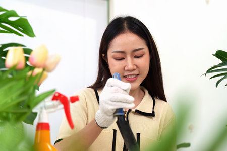Gardening and Sustainability. A woman enjoys nurturing her plants, promoting a hobby that fosters ecological awareness and personal well-being.の写真素材