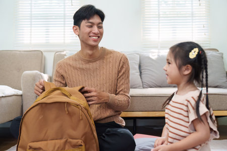 Back to School and Learning. A joyful interaction between a father and daughter as they prepare for school, showcasing essential supplies.の写真素材