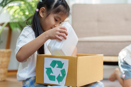 Sustainable Practices and Family Engagement. A child learns recycling through hands-on activities with her family.の写真素材