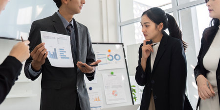 Business Presentation and Team Collaboration. A focused meeting where team members discuss data insights from charts and graphs.の写真素材
