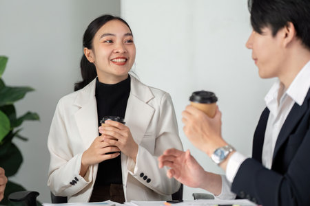 Team Discussion and Idea Exchange. Young professionals sharing coffee while discussing key business strategies.の写真素材