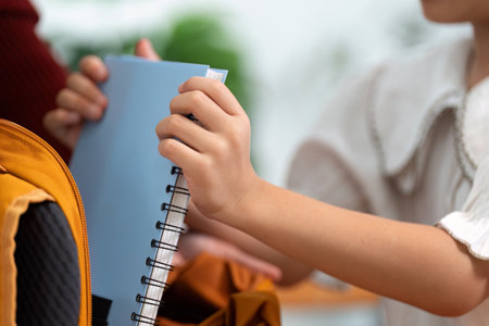 Student Readiness and Enthusiasm. A child reaches for her notebook as she prepares to start school.の写真素材