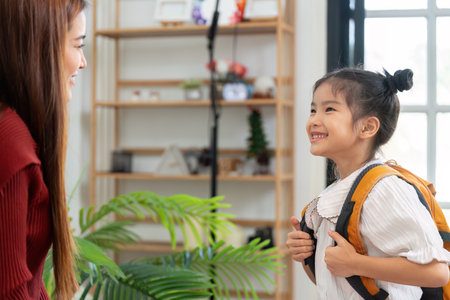 Joyful Preparation for a New Day. A girl smiles brightly as she prepares for her school adventure.の写真素材