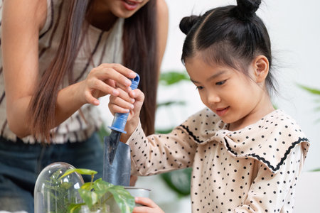 Planting and Education. A girl learns how to plant as her mother guides her with nurturing hands.の写真素材