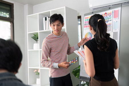Visual Presentation and Group Dynamics. A team member presenting design work while others...