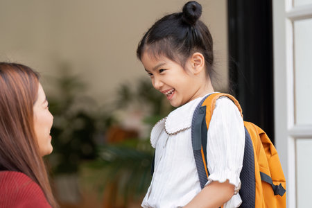 Smiles and Confidence. A girl shares a heartfelt moment with her mother before leaving for school.の写真素材