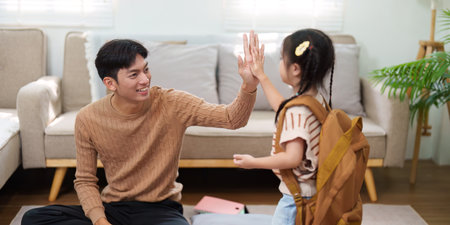 Back to School and Happy Moments. A father sharing a joyful high-five with his daughter before school.の写真素材