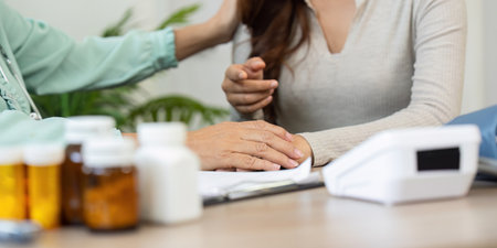Medical Consultation and Patient Interaction. An elderly doctor engaging a patient with care and attentiveness during a consultation.の写真素材