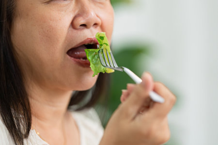 Nutrition and Wellness. An elderly woman enjoying a fresh salad as part of her healthy eating routine.の写真素材