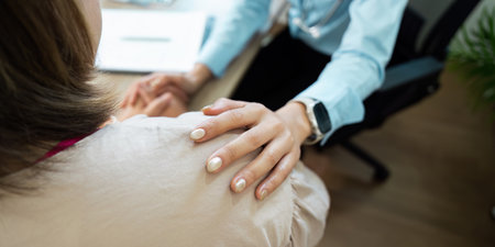 Emotional Support and Patient Care. A healthcare worker offers comfort to a patient during a consultation.の写真素材