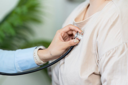 Patient Examination and Health Monitoring. A healthcare professional performing a stethoscope examination on a patient.の写真素材