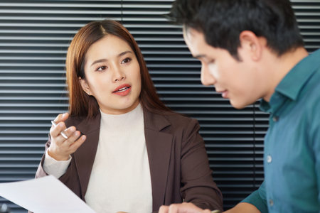 Communication and Presentation. A professional woman presenting business insights while fostering engagement with her colleague.の写真素材