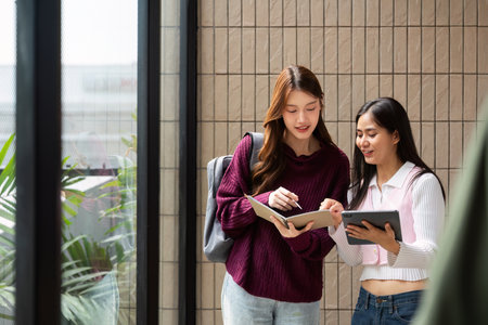 Study Collaboration and Engagement. Friends discussing their coursework while exploring resources together.の写真素材