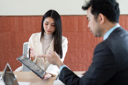 Business Discussion and Collaboration. A professional meeting between colleagues discussing insights and strategies with digital devices.の写真素材