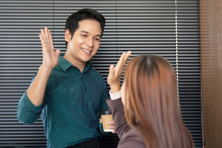 Business Interaction and Professional Networking. A friendly greeting between colleagues in an office setting.の写真素材