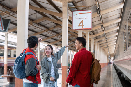 Exploration and Direction. Friends excitedly read the platform sign while preparing for their next...
