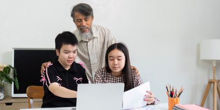 Back to School and Supportive Learning. A girl with Down syndrome receives guidance from her grandfather while preparing for school.の写真素材