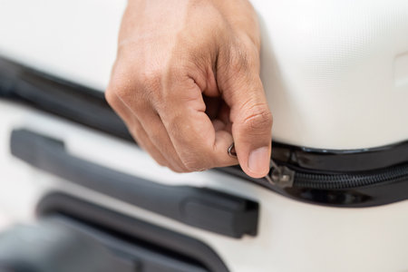 Zipping Up and Finalizing Luggage. A close-up of a hand zipping a suitcase, ready for the travel adventure ahead.の写真素材