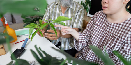 Nature and Learning. A child points to a plant while an adult shares knowledge about gardening.の写真素材