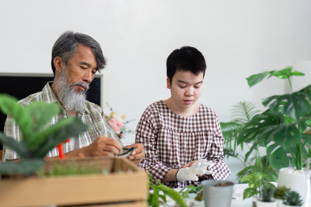 Sustainable Gardening and Family Bonding. A girl with Down syndrome learns gardening skills from her grandfather.の写真素材