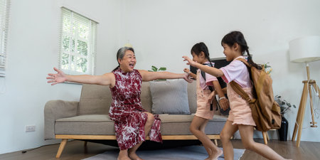 Excitement and Family Reunion. Grandmother joyfully welcomes her granddaughters as they rush to her with open arms.の写真素材