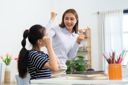 Back to School Celebration. Teacher and student share joyful success at home.の写真素材