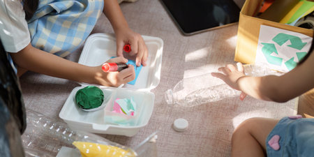 Creative Recycling and Sustainable Education. Children engaged in transforming used materials into artistic projects focused on environmental stewardship.の写真素材