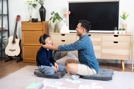 Back to School Fun. Father and son enjoying playful learning with headphones.の写真素材