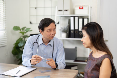 Doctor-Patient Discussion and Medical Guidance. A physician explaining treatment options to a patient in a clinical setting.の写真素材