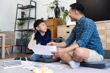 Back to School Study Session. Father and son collaborating on homework at home.