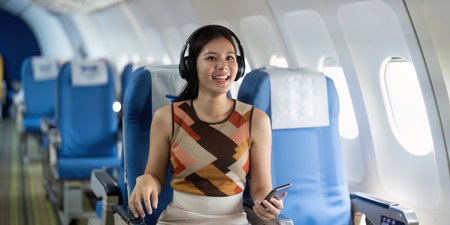 Journey and Travel. Happy traveler enjoying flight with headphones and smartphone.
