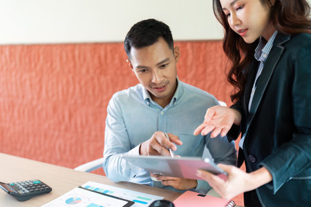 Collaboration in Business. Professionals discussing data on tablet in modern office.の写真素材