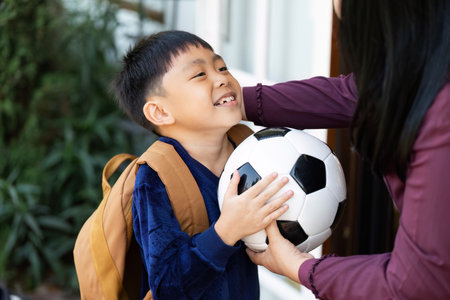 Back to School and Soccer Excitement. A young boy with a backpack and soccer ball, smiling as he prepares for school.の写真素材